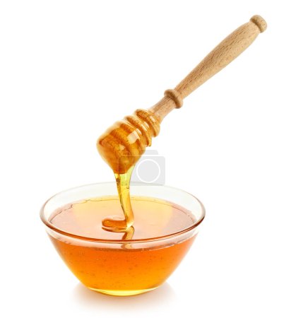 Photo for Glass bowl full of honey and wooden dipper with dripping honey isolated on white background - Royalty Free Image