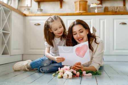 Photo for Happy mother's day. Child daughter congratulating her mother and giving her bouquet of flowers. - Royalty Free Image