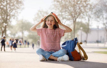 Foto de Alumno de primaria. Chica con mochilas al aire libre. Comienzo de las lecciones. Primer día de otoño. - Imagen libre de derechos
