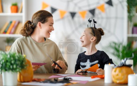 Téléchargez les photos : Joyeux Halloween, mère et sa fille sculptant la citrouille. Préparation familiale pour les vacances. - en image libre de droit