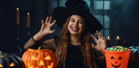 Photo for Cute teenage witch with a carved pumpkin. Beautiful young girl in carnival costume. Halloween Party concept. - Royalty Free Image