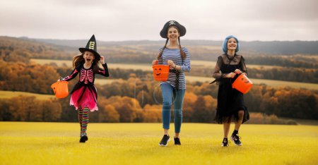 Téléchargez les photos : Les enfants heureux courent à la fête d'Halloween. Les enfants portent des costumes de carnaval. - en image libre de droit