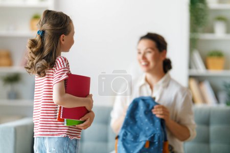 Téléchargez les photos : Bonne famille se préparant pour l'école. Petite fille avec mère. - en image libre de droit