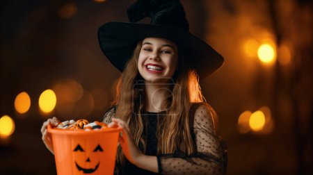 Photo for Cute teenage witch with a carved pumpkin. Beautiful young girl in carnival costume. Halloween Party concept. - Royalty Free Image