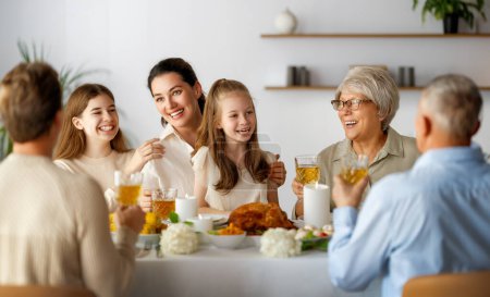 Téléchargez les photos : Jour de Thanksgiving, fête d'automne. Joyeux famille assise à la table et célébrant les vacances. Grand-parents, mère, père et enfants. Dîner traditionnel. - en image libre de droit