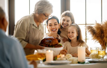 Photo for Thanksgiving Day, Autumn feast. Happy family sitting at the table and celebrating holiday. Grandparents, mother and children. Traditional dinner. - Royalty Free Image