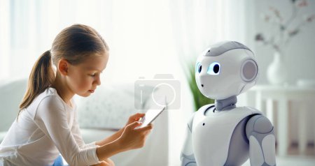 Photo for A cute girl is playing with a robot. The concept of future training. - Royalty Free Image