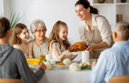 Téléchargez les photos : Jour de Thanksgiving, fête d'automne. Joyeux famille assise à la table et célébrant les vacances. Grand-parents, mère, père et enfants. Dîner traditionnel. - en image libre de droit