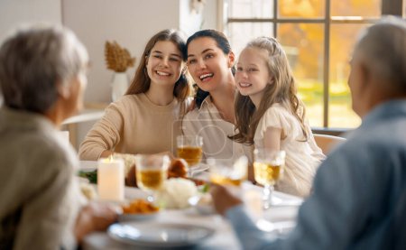 Foto de Día de Acción de Gracias, fiesta de otoño. Feliz familia sentada a la mesa y celebrando la fiesta. Abuelos, madre e hijos. Cena tradicional. - Imagen libre de derechos