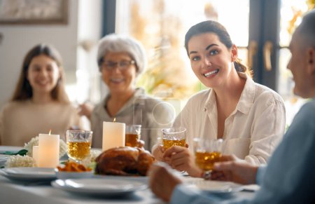 Téléchargez les photos : Jour de Thanksgiving, fête d'automne. Joyeux famille assise à la table et célébrant les vacances. Grand-parents, mère et enfants. Dîner traditionnel. - en image libre de droit