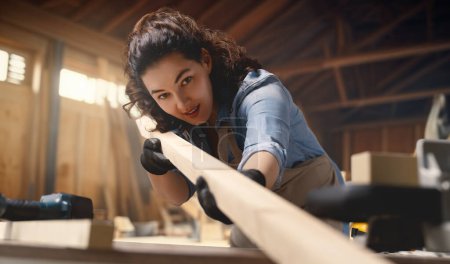 Photo for Young woman carpenter is working in a workshop. - Royalty Free Image
