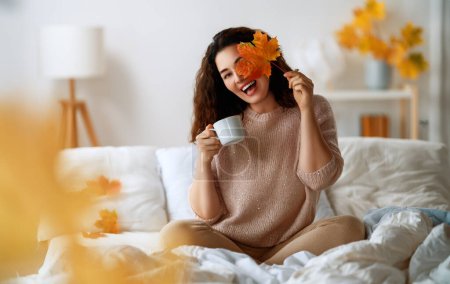 Téléchargez les photos : Joyeux jeune femme profitant matin ensoleillé sur le lit. - en image libre de droit