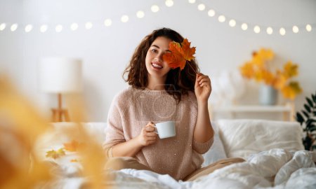 Photo for Happy young woman enjoying sunny morning on the bed. - Royalty Free Image