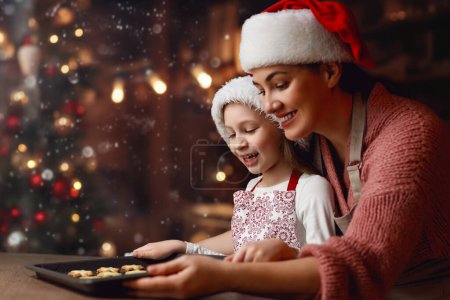 Photo for Merry Christmas and Happy Holidays. Family preparation holiday food. Mother and daughter cooking pie. - Royalty Free Image