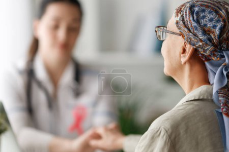 Photo for Colour ribbon for concept of illness awareness. Female patient listening to doctor in medical office. Raising knowledge on people living with disease. - Royalty Free Image