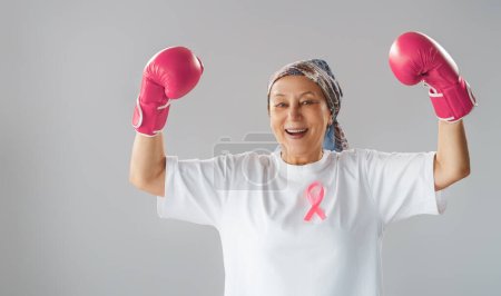 Photo for Woman in boxing gloves with a pink ribbon as a symbol of the fight against cancer. Increasing the level of knowledge about people who have overcome tumor diseases. - Royalty Free Image