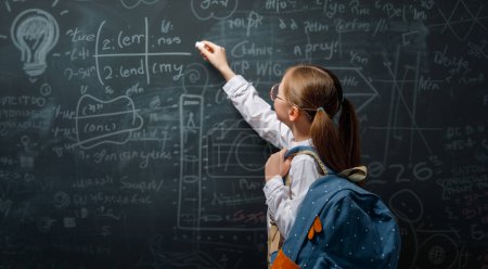 Photo for Back to school. Happy cute industrious child indoors. Kid is learning in class on background of blackboard. - Royalty Free Image