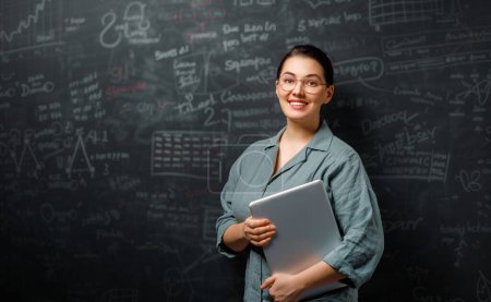 Photo for Back to school. Happy teacher indoors. Woman is standing in class on background of blackboard. - Royalty Free Image