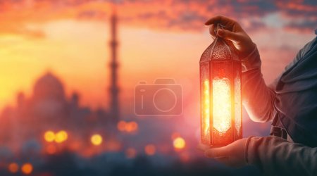 Photo for Woman is holding Ornamental Arabic lantern with burning candle glowing at night mosque background. Festive greeting card, invitation for Muslim holy month Ramadan Kareem. - Royalty Free Image