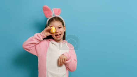 Photo for Cute little child wearing bunny ears on Easter day. Girl with painted egg. - Royalty Free Image