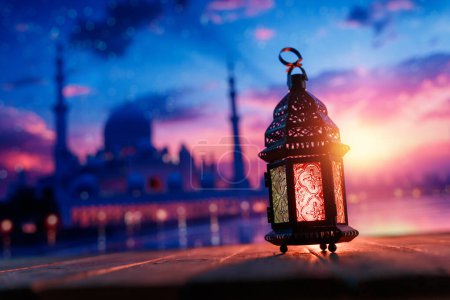 Téléchargez les photos : Lanterne arabe ornementale avec bougie allumée qui brille à l'arrière-plan de la nuit. Carte de vœux festive, invitation pour le mois saint musulman Ramadan Kareem. - en image libre de droit