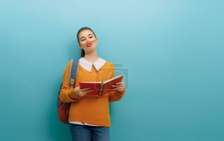 Photo for Back to school and happy time. Cute industrious teenager on color paper wall background. Girl with backpack. Teen ready to study. - Royalty Free Image