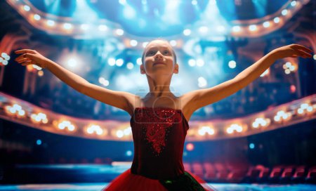 Foto de Linda niñita soñando con convertirse en bailarina. Niña en un tutú rojo bailando en el escenario. - Imagen libre de derechos