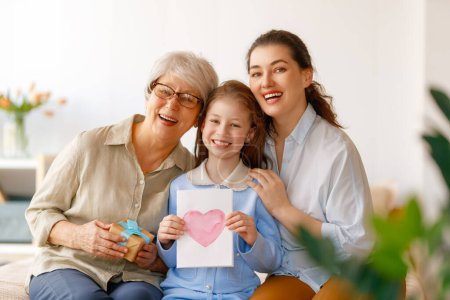 Photo for Happy mother's day. Child, mom and granny with gaft box and postcard. Grandma, mum and girl smiling. Family holiday and togetherness. - Royalty Free Image