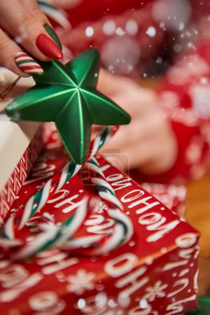 Foto de Escena navideña con caja de regalo blanca, lazo y cinta roja, velas, luces, adornos, ramas de abeto y nieve, con espacio para copiar - Imagen libre de derechos