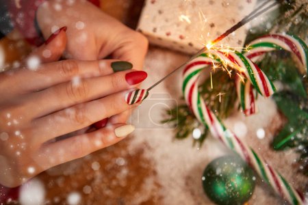 Foto de Escena navideña con caja de regalo blanca, lazo y cinta roja, velas, luces, adornos, ramas de abeto y nieve, con espacio para copiar - Imagen libre de derechos