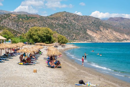 Téléchargez les photos : PALEOCHORA, CRETE, GRÈCE - 22 JUILLET 2021 : Les touristes se reposent sur la plage de galets de Chalikia - en image libre de droit