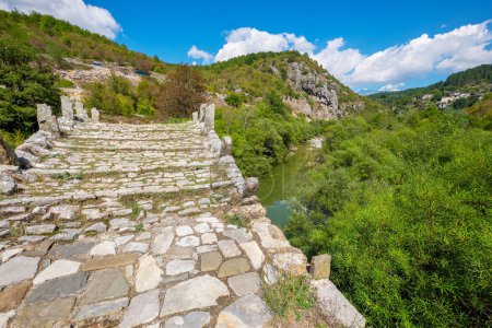 Téléchargez les photos : View to stone bridge of Kalogeriko (or Plakida) over Voidomatis river. Central Zagoria, Epirus, Greece - en image libre de droit