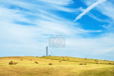 Photo for View to field on a hillside with hay bales and tower. Shropshire, England, UK - Royalty Free Image