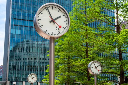 Photo for Public clocks in square at Canary Wharf area. London, England - Royalty Free Image