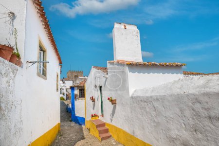 Téléchargez les photos : Façades de petites maisons dans une rue étroite à Obidos médiévale, Portugal - en image libre de droit