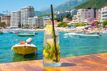 Photo for Fresh mojito cocktail on wooden table in outdoor cafe. Rafailovici, Montenegro - Royalty Free Image