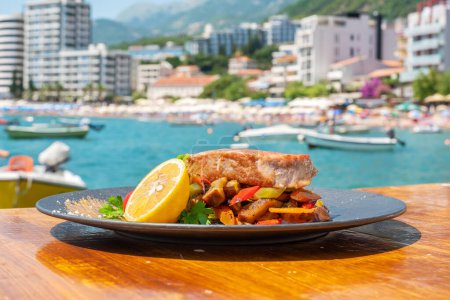 Photo for Roasted tuna fish steak on black plate in outdoor cafe. Rafailovici, Montenegro - Royalty Free Image