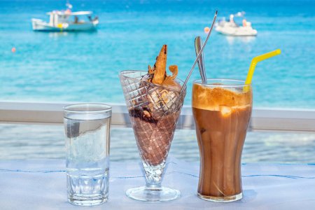 Photo for Glasses of water, ice cream and frappe on a table in seaside cafe. Rhodes, Greece - Royalty Free Image
