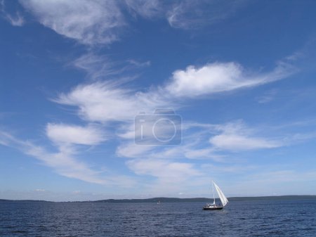 sailing boat on Lake Onega in summer, blue sky with clouds 