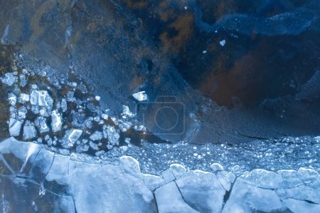 Foto de Hielo en un río helado. Textura de fondo de hielo azul con grietas en la nieve. vista superior del dron. - Imagen libre de derechos