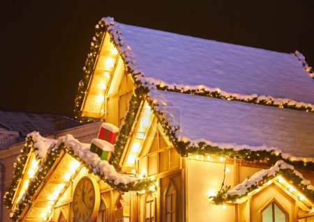 Téléchargez les photos : Couronne de Noël inhabituelle sur la fenêtre. front de magasin décoré de luxe avec guirlande lumières dans la rue de la ville européenne pendant les vacances saisonnières d'hiver - en image libre de droit