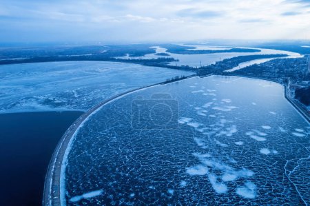 Foto de Rompeolas que conducen al mar Báltico en invierno. Mar cubierto de niebla y bloques de hielo. Hermoso faro al amanecer. - Imagen libre de derechos