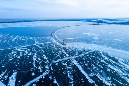 Téléchargez les photos : Brise-lames menant à la mer Baltique en hiver. Mer couverte de brouillard et de blocs de glace. Magnifique phare au lever du soleil. - en image libre de droit