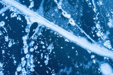 Foto de Hielo en un río helado. Textura de fondo de hielo azul con grietas en la nieve. vista superior del dron. - Imagen libre de derechos