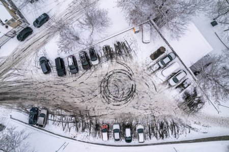 Téléchargez les photos : Voitures dans le parking couvert de neige. Automobiles neige dérive par la route dans la cour de la maison. Vue aérienne du dessus. Le concept d'une mauvaise matinée d'hiver. - en image libre de droit