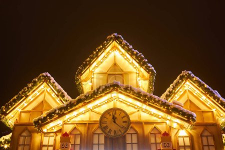 Foto de Corona de Navidad inusual en la ventana. tienda decorada de lujo frente con luces de guirnalda en la calle de la ciudad europea en las vacaciones de temporada de invierno - Imagen libre de derechos