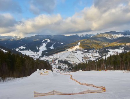 Téléchargez les photos : Couple ski dans une piste de ski double courbe damée avec sommets de montagne et une formation de nuages caractéristique en arrière-plan dans les montagnes nordiques à l'est
. - en image libre de droit