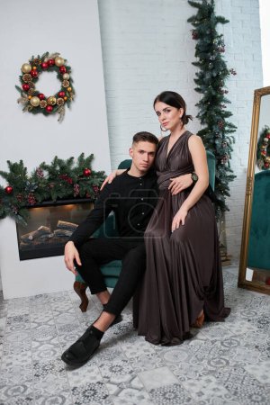 Photo for Beautiful couple in love. Cheerful young couple in elegant evening clothing. Fashion, glamour. Couple hugging in christmas decorated interior - Royalty Free Image
