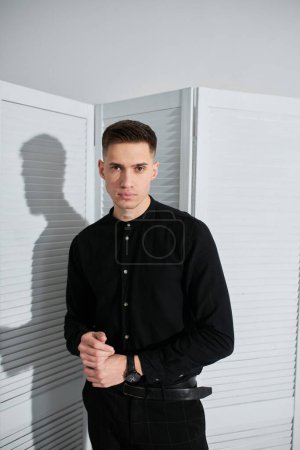 Téléchargez les photos : Beau jeune homme posant en chemise noire - en image libre de droit