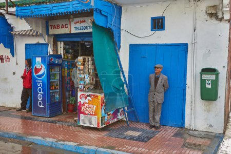 Téléchargez les photos : ESSAOUIRA, MOROCCO. 12 th February, 2017: Streets of the old city, Medina, colorful houses. People rushing to work, the city after the rain - en image libre de droit